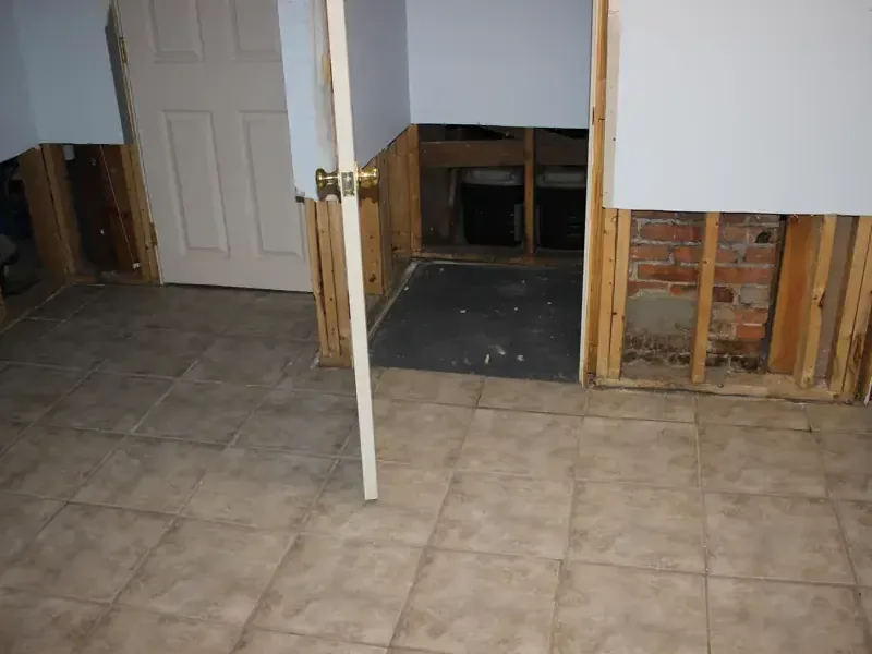 Lower drywall removed around a tiled room during water damage drying