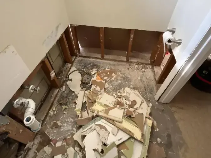 Removed wall finishes and debris on a bathroom floor