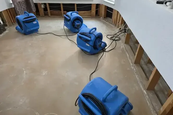 Drying equipment positioned inside a room during a water damage dry-out