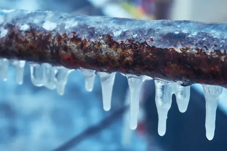 Ice hanging beneath an exposed frozen water supply pipe