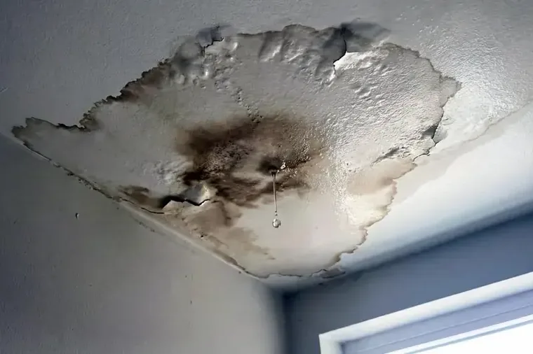 Stained ceiling drywall sagging beneath an area of water damage